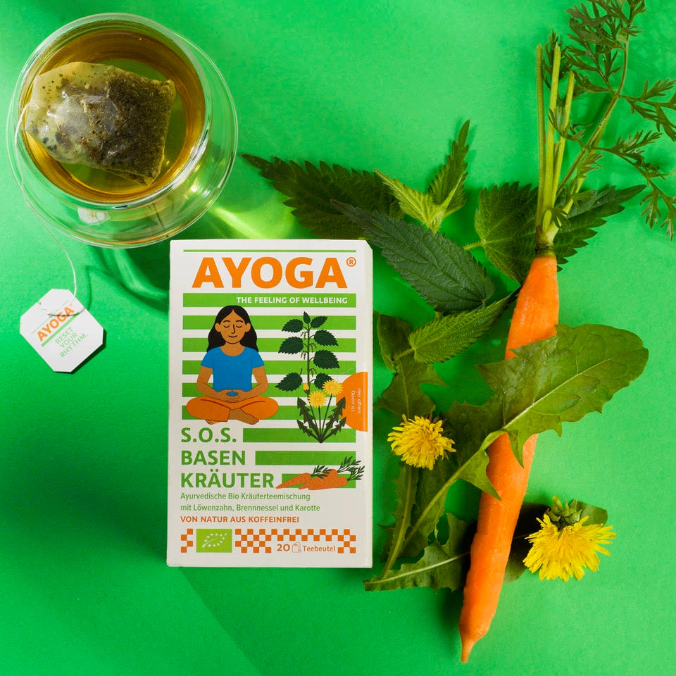 SOS. Tisane alcaline sur fond vert avec un verre à thé, des carottes et des pissenlits.