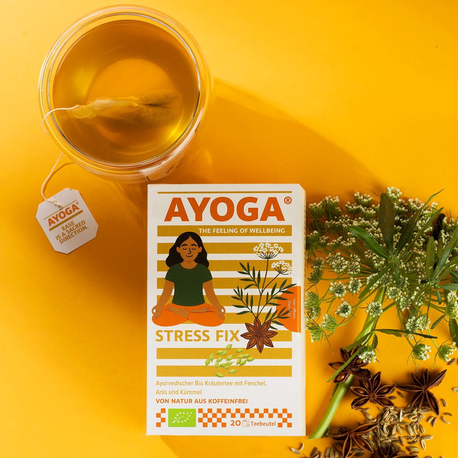 Stress Fix Tee verpackt mit einer Tasse Tee und Anis auf orangefarbenem Hintergrund.